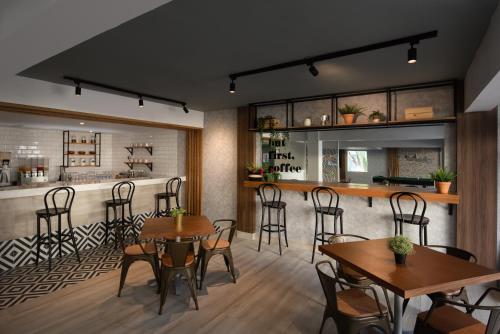 a restaurant with wooden tables and chairs and a bar at Select at Casa Marina Adults Only All Inclusive in Sosúa