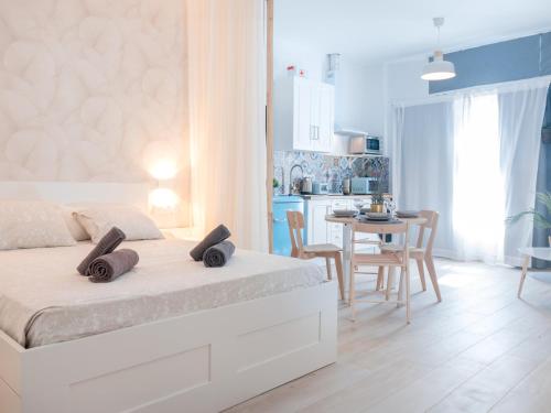 a white bedroom with a bed and a table with chairs at ISG Apartments Triana Jacuzzi 1 in Seville