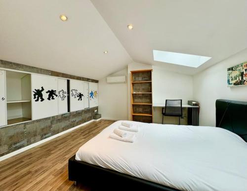 une chambre avec un grand lit blanc dans une pièce dans l'établissement A l Urban de Champagne - Reims, à Reims