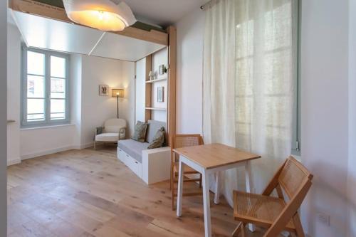 un salon avec une table et un canapé dans l'établissement #59 Central balcony 5mins Old town & Sea AC WIFI, à Nice