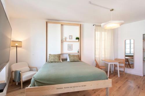 une chambre avec un lit, une chaise et une table dans l'établissement #59 Central balcony 5mins Old town & Sea AC WIFI, à Nice