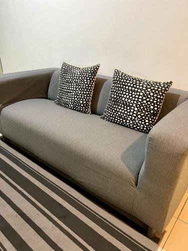 a gray couch with two pillows on it at 7 STAY#1 - 1 Room for 3 Pax at Kuala Berang -Best Travelers Stay in Kuala Berang