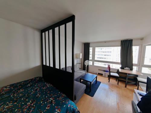 une chambre avec un lit et un salon dans l'établissement Appartement lumineux proche de la ligne 14, à Paris