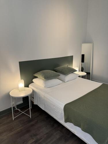 - une chambre avec un grand lit et 2 tables dans l'établissement cite 4 Maison Bacou, à Carcassonne