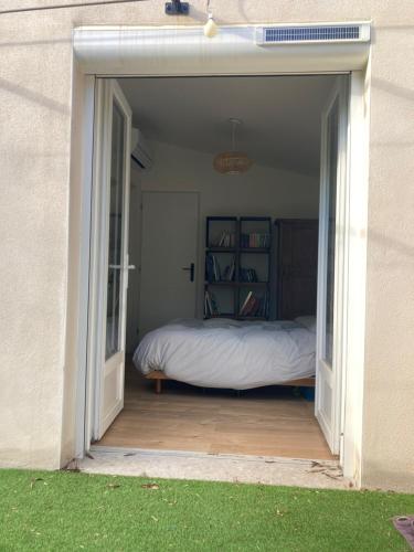 - une chambre avec un lit à l'intérieur d'une porte dans l'établissement Le mazet des 3 piliers, à Nîmes