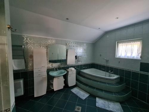 a bathroom with a sink and a tub and a toilet at Zöldház in Balatonmáriafürdő