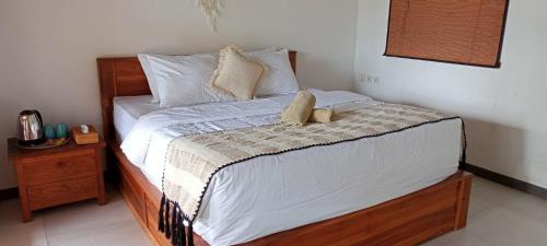 a bed with two stuffed animals sitting on it at Joglow Clasica Uluwatu in Uluwatu
