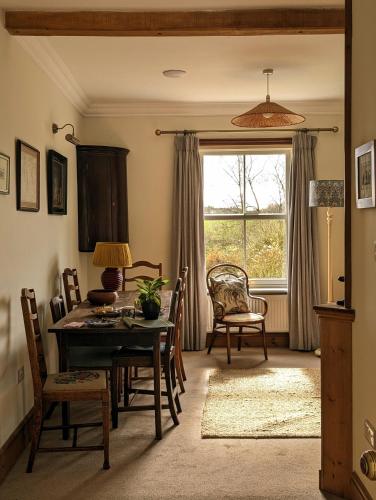 Un comedor con mesa y sillas y una ventana. en Garden View Apartment, en Oswestry