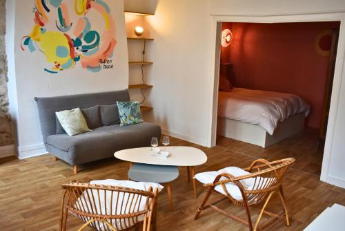 un salon avec un canapé, une table et des chaises dans l'établissement L'authentique - Centre - Calme - Équipé - Basque, à Bayonne
