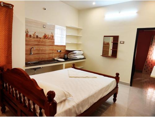 a bedroom with a bed and a sink in it at Vijayaa Homes in Tiruvannāmalai