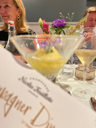 a woman sitting at a table with a drink at ONNO Boutique Hotel & Apartments in Rendsburg