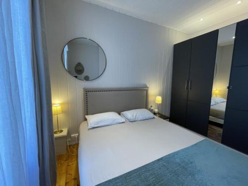 une chambre avec un lit blanc et un miroir dans l'établissement Coeur du Boulingrin, à Reims