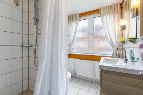 a white bathroom with a shower and a sink at Atlanta Pur in Pellworm