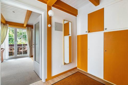 a hallway with orange and white walls and a mirror at Atlanta Pur in Pellworm