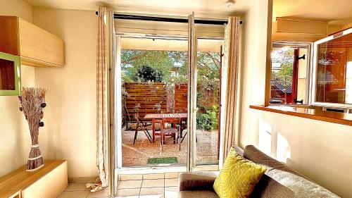d'un salon avec une porte coulissante en verre s'ouvrant sur une terrasse. dans l'établissement Appartement 4 personnes 10 min Disney, à Montévrain