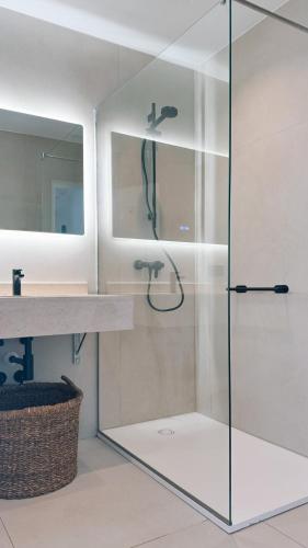 a glass shower in a bathroom with a sink at Hostal SA Roqueta Mahon in Mahón
