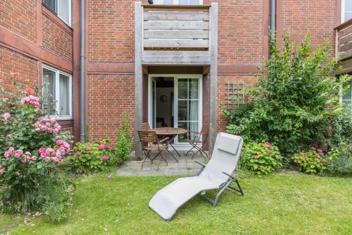 a white chair sitting in a yard next to a building at Atlanta Pur in Pellworm