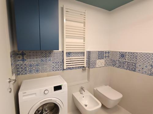 une salle de bain avec machine à laver et toilettes dans l'établissement La Scarpa della Strega, à Chioggia