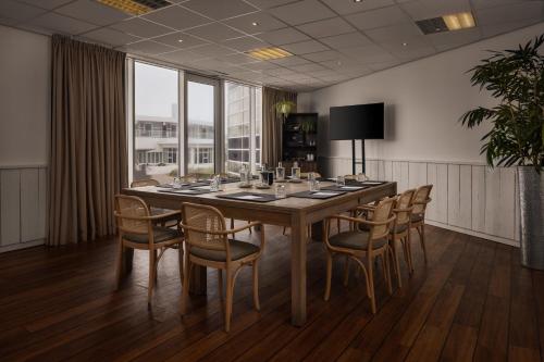a conference room with a long table and chairs at WestCord Strandhotel Seeduyn in Oost-Vlieland