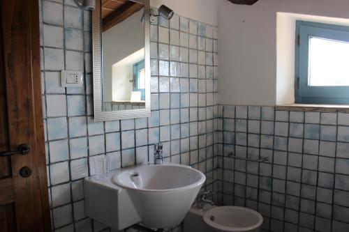 a bathroom with a sink and a mirror and a toilet at Monteriggioni Suite in Monteriggioni