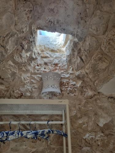 a room with a stone wall with a window at Trulli Di Spinaruta in Grottaglie