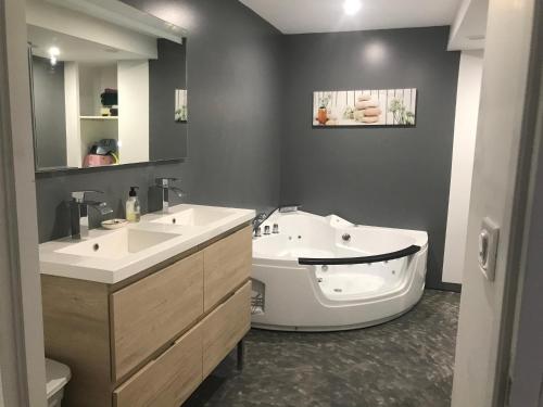 une salle de bain avec deux lavabos et une baignoire dans l'établissement Gîte 10 personnes Ardèche Jacuzzi, à Saint-Apollinaire-de-Rias