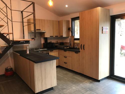 une cuisine avec des armoires en bois et un comptoir dans l'établissement Gîte 10 personnes Ardèche Jacuzzi, à Saint-Apollinaire-de-Rias