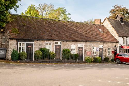 a brick building with a red car parked in front at Gaskell Arms in Much Wenlock