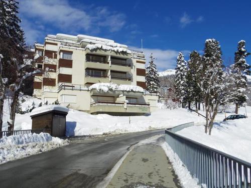 a building with snow on the side of a road at Mountain Loft - DuLac 33 in St. Moritz