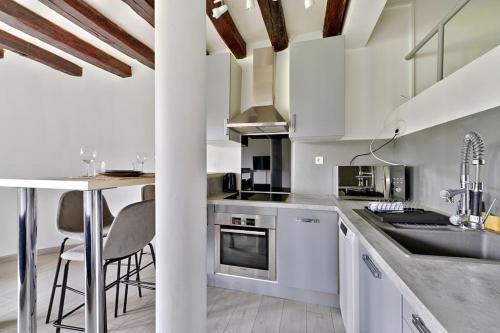 - une cuisine avec des placards blancs et un comptoir avec un évier dans l'établissement Cosy Farm House, à Wissous