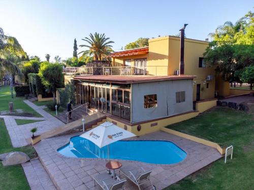 a house with a swimming pool in front of it at Sunriver Kalahari Lodge Riverside stay in Upington in Upington