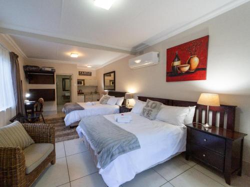 a hotel room with two beds and a couch at Sunriver Kalahari Lodge Riverside stay in Upington in Upington