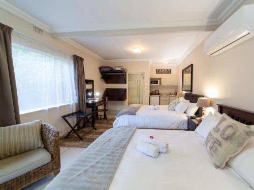 a hotel room with two beds and a couch at Sunriver Kalahari Lodge Riverside stay in Upington in Upington