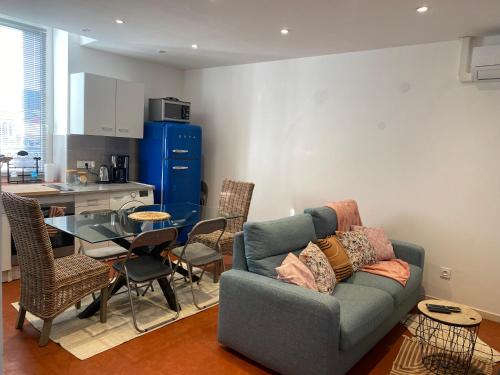 un salon avec un canapé et une table en verre dans l'établissement T2 climatisé - Près des plages, à Narbonne