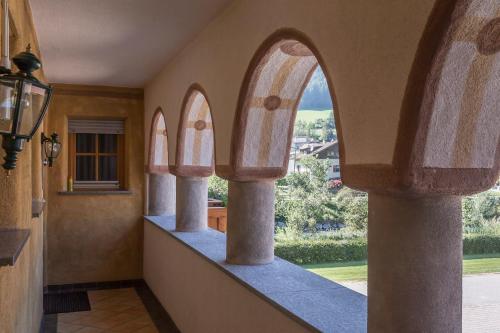 a hallway with three arched windows in a house at Anewandterhof in Brunico