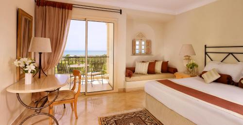 a bedroom with a bed and a table and a balcony at The Residence Tunis in Gammarth