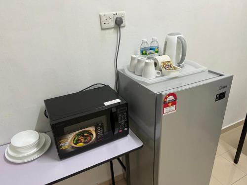 a microwave on a table next to a refrigerator at 7 STAY#1 - 1 Room for 3 Pax at Kuala Berang -Best Travelers Stay in Kuala Berang