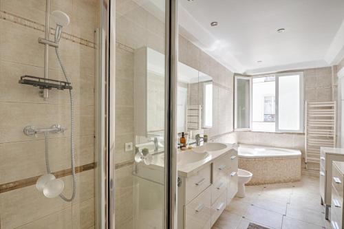 une salle de bain avec une douche, un lavabo et une baignoire dans l'établissement Le Petit Hôtel - Appt 6p 127 m² à Paris, à Paris
