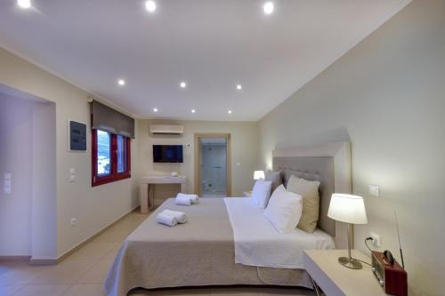 a large bedroom with a large bed and a table at KEOS by the sea in Korissia
