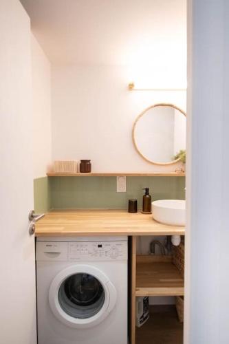 une machine à laver dans une salle de bain avec un lavabo dans l'établissement Pylos - Évasion haut de gamme, vue sur le port, à Capbreton