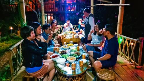 a group of people sitting around a table at A Páo Homestay in Bản Hon