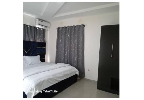 a bedroom with a bed and a black curtain at YP-Made Luxurious 1 & 2 Bedroom Apartments in Eluju