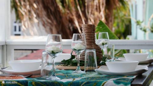 a table with glasses and plates on a table at 4BlessingsCuracao2 in Willemstad
