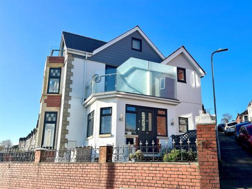 a white house with a window on top of a brick wall at Redlands House By Urban Hideaways in Barry
