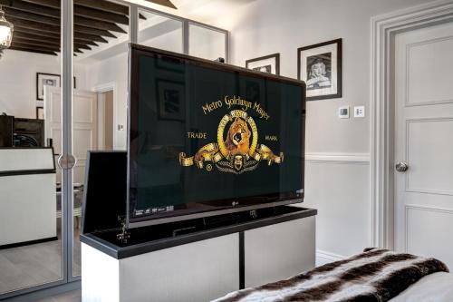 a large flat screen tv on a stand in a room at Beautiful & Luxurious 3 bed home, with amazing terrace in London