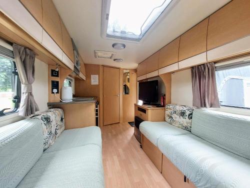 an interior view of a campervan with a tv and windows at Billie in Hope
