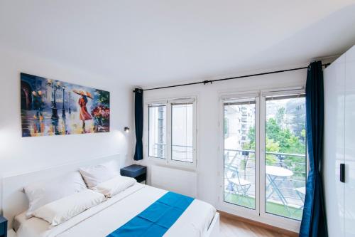 una camera da letto con un letto e una grande finestra di Paris Porte de Versailles - ISSYHOST a Issy-les-Moulineaux