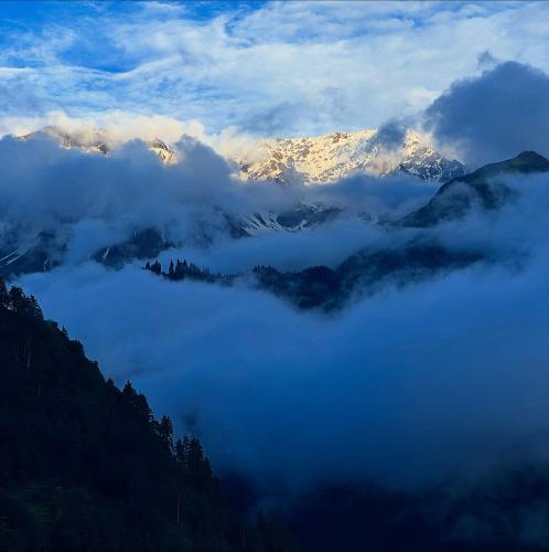a view of a mountain covered in clouds and snow at Cafekush tosh in Tosh