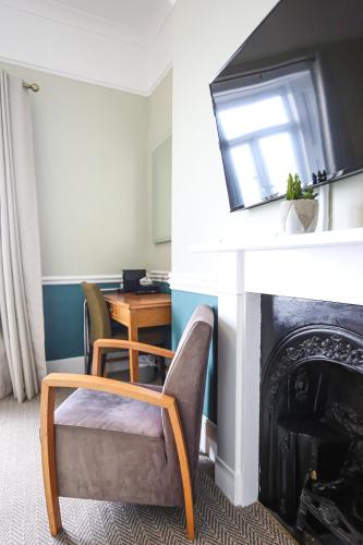 a living room with a chair and a fireplace at The Wellington Hotel in Ventnor