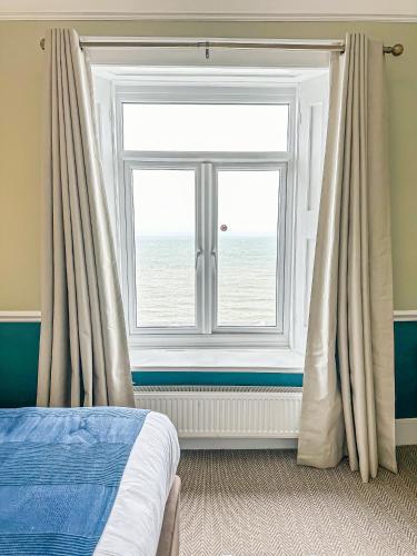 a bedroom with a window and a bed with curtains at The Wellington Hotel in Ventnor